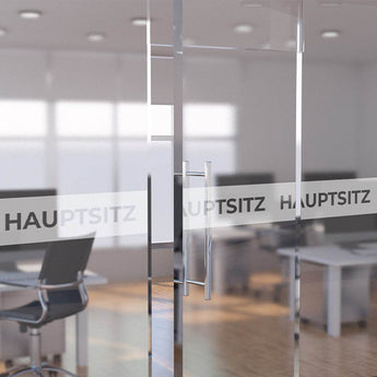 Glastür im Büro mit bedrucktem Sichtschutz-Streifen und der Aufschrift Hauptsitz. Hier individuelle Klebefolie drucken.
