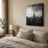 Leinwand Bedrucken – ein großes Schwarz-Weiß-Bild der New Yorker Skyline, das als elegante Wanddekoration über einem Bett in einem gemütlichen, in Beigetönen gehaltenen Schlafzimmer hängt.