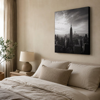 Leinwand Bedrucken – ein großes Schwarz-Weiß-Bild der New Yorker Skyline, das als elegante Wanddekoration über einem Bett in einem gemütlichen, in Beigetönen gehaltenen Schlafzimmer hängt.