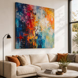 Leinwand Bedrucken – ein großes, farbenfrohes abstraktes Kunstwerk, das in einem lichtdurchfluteten Wohnzimmer als stilvolle Wanddekoration über einem beigen Sofa hängt.