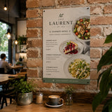 Poster drucken – ein ästhetisches Speisekarten-Poster für ein Café mit ansprechenden Food-Fotos eines Sommer-Menüs, das dekorativ an einer rustikalen Backsteinwand hängt.
