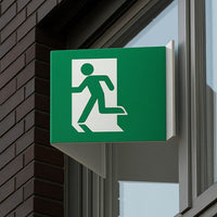 Grünes Fluchtweg-Nasenschild an einer Fensterfront. Wir drucken Ihr individuelles Motiv, z.B. als Maklerschild.