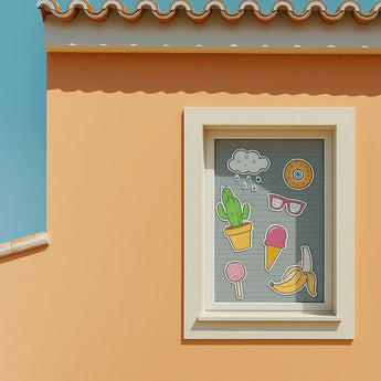 Fenster verziert mit bunten Stickern wie Kaktus und Eis. Für solche kreativen Motive können Sie Klebefolie drucken.