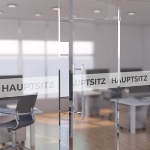 Glastür im Büro mit bedrucktem Sichtschutz-Streifen und der Aufschrift Hauptsitz. Hier individuelle Klebefolie drucken.