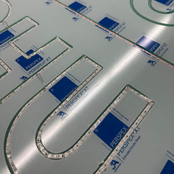 In Kanäle eingelegte LED-Streifen auf einer Perspex Acrylglasplatte. Vorbereitung für den Bau von Neon Leuchtschriften.