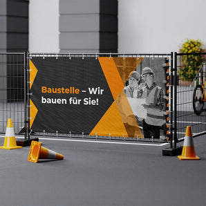 Winddurchlässiges Mesh-Banner auf einem Bauzaun bei starkem Tageslicht