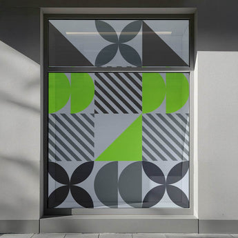 Transparente Fensteraufkleber mit modernem grau-grünem Geometrie-Muster auf einer Außenfensterscheibe.